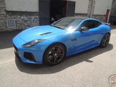the blue sports car is parked in front of a building