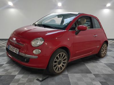 the small red car is parked on a checkered tile floor