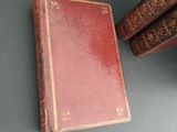 two old books sitting on top of a table next to each other