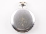 a small silver pocket watch on a white surface
