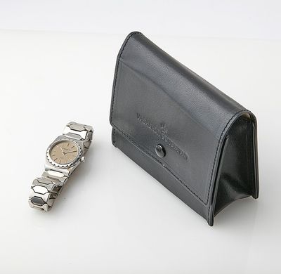 a watch sitting next to a wallet on a table