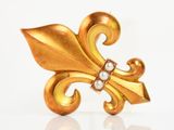 an image of a close up of a gold broochle with pearls