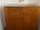a wooden cabinet with two drawers in the corner of a room