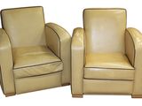 une paire de fauteuils club en cuir crème avec passepoil noir
