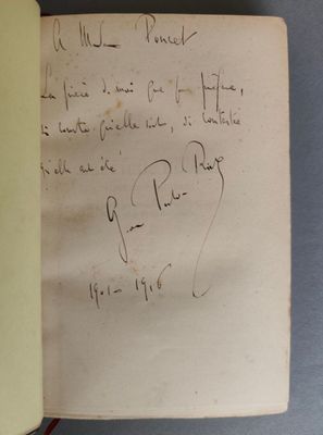 un livre ouvert, sur lequel est posée une note manuscrite, posé sur une table