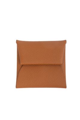 un sac enveloppe en cuir orange muni d'une fermeture à glissière, sur fond blanc
