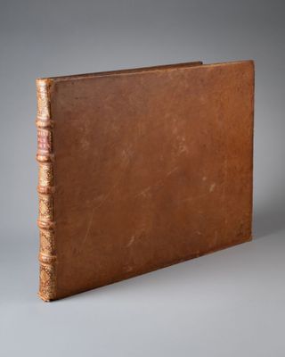 un vieux livre à la couverture brune posé sur une table
