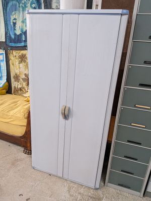 un réfrigérateur blanc posé à côté d'un lit dans une chambre