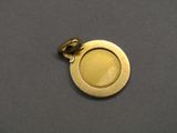 a close up of a gold plated metal button on a gray surface