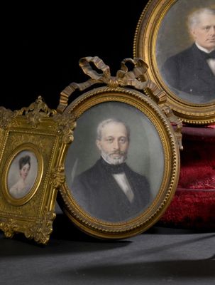 deux portraits encadrés représentant un homme et une femme assis sur une chaise