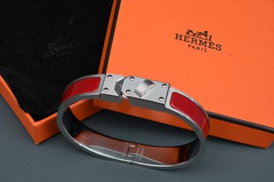 une boîte orange contenant un bracelet en argent et une boîte noire avec un fermoir en argent