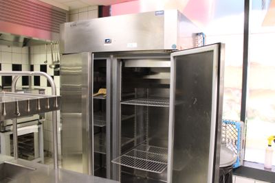 un grand réfrigérateur en acier inoxydable dans une cuisine professionnelle