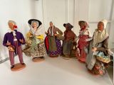 sept figurines représentant des personnes vêtues de costumes différents