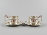 une paire de tasses à thé et de soucoupes en métal argenté