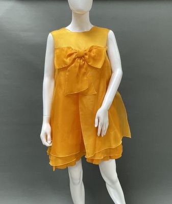 mannequin wearing a yellow dress with a bow on the front