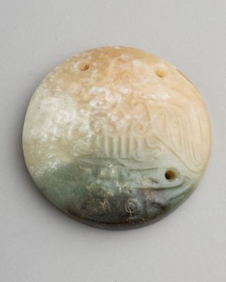 une photo d'un objet blanc et vert posé sur une surface blanche