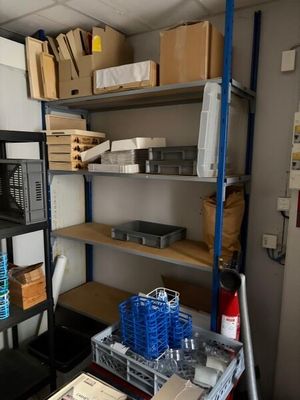 une pièce remplie d'étagères et de bacs contenant des cartons