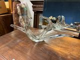 a glass bird sitting on a table with a mirror in the background