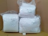 trois paquets de papier toilette blanc posés sur une boîte en carton