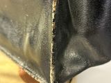 a close up of a hand holding a black purse