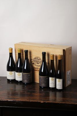 six bouteilles de vin sont posées dans une caisse en bois sur une table
