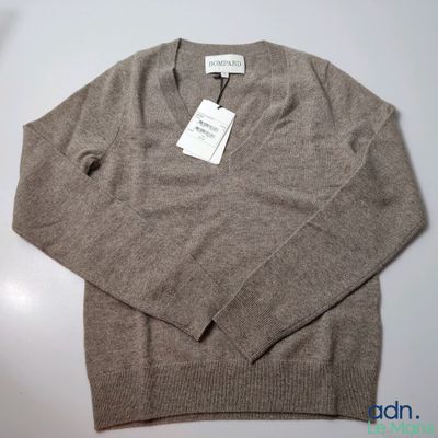 an image of a sweater with a tag on it sitting on a table