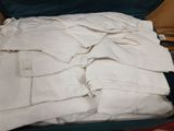 a suit case filled with white pants and a pair of shoes