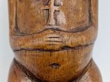 an image of a wooden statue of a man with a cross on his chest