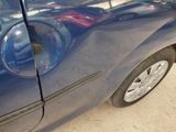 a close up of a blue car with a hole in the door