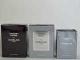 three boxes of perfume sitting next to each other on a white surface