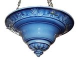 a blue bowl hanging from a chain on a white wall