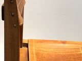 a wooden chair that has a leather seat on top of it