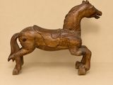a wooden horse that is standing on a shelf
