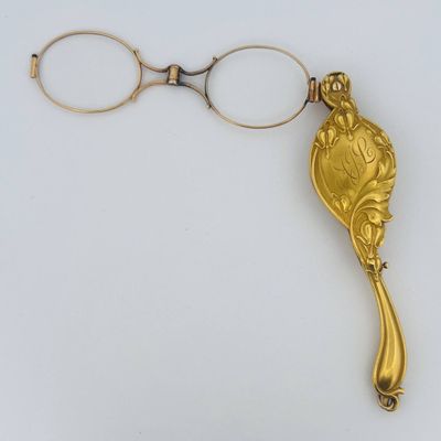 a gold spoon and a pair of scissors on a white surface