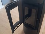a black stove sitting on top of a wooden floor