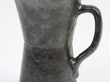 a black pitcher that is sitting on a white surface