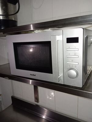 un micro-ondes posé sur une étagère dans une cuisine