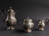 three silver teapots and a coffee pot sitting on a table