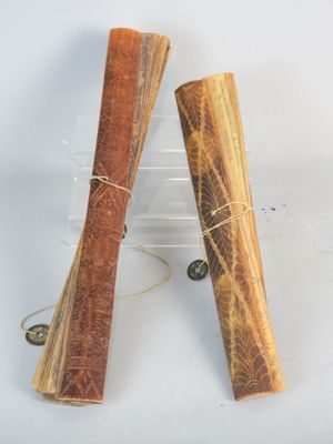 deux bâtonnets d'encens en bois, enroulés dans de la ficelle, posés sur une surface blanche