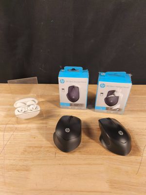 deux souris sans fil noires posées sur une table en bois