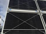 an industrial cooling unit with a sky background and clouds in the background