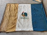un grand drapeau avec un coq posé sur le sol