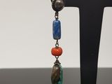 a close up of a pair of earrings on a stand