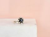 une bague en diamant noir posée sur un bloc de marbre blanc