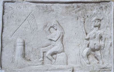 carvings of a man and a woman are on a stone wall