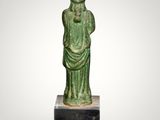 a green statue of a woman with a hat on her head