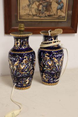 two blue vases sitting on a table next to a painting