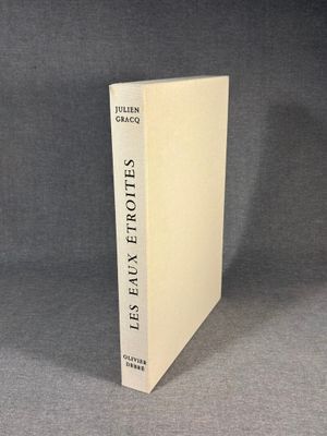 a white book sitting on top of a table next to a gray wall