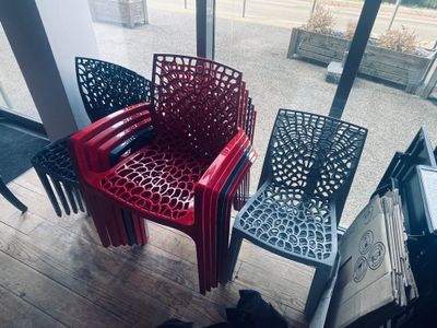 trois chaises en plastique alignées les unes à côté des autres devant une fenêtre
