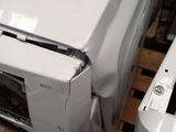a white washing machine sitting on a pallet next to a white washer